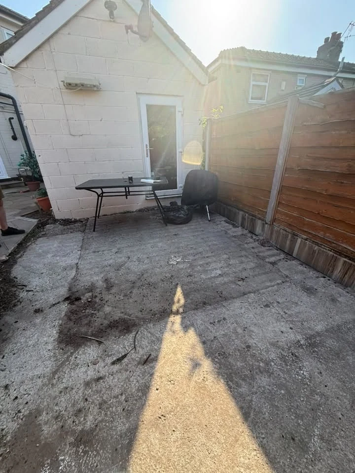 Northwich garden before the transformation, with an unfinished surface beside the outbuilding