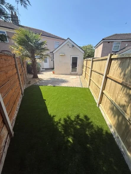 New artificial lawn and stone path leading towards the garden outbuilding in Northwich