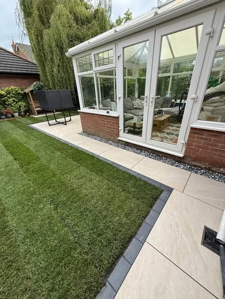 Porcelain paving and dark edging outside the garden room doors