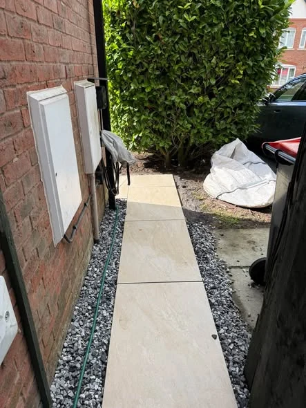 Pale porcelain path and dark gravel beside the house