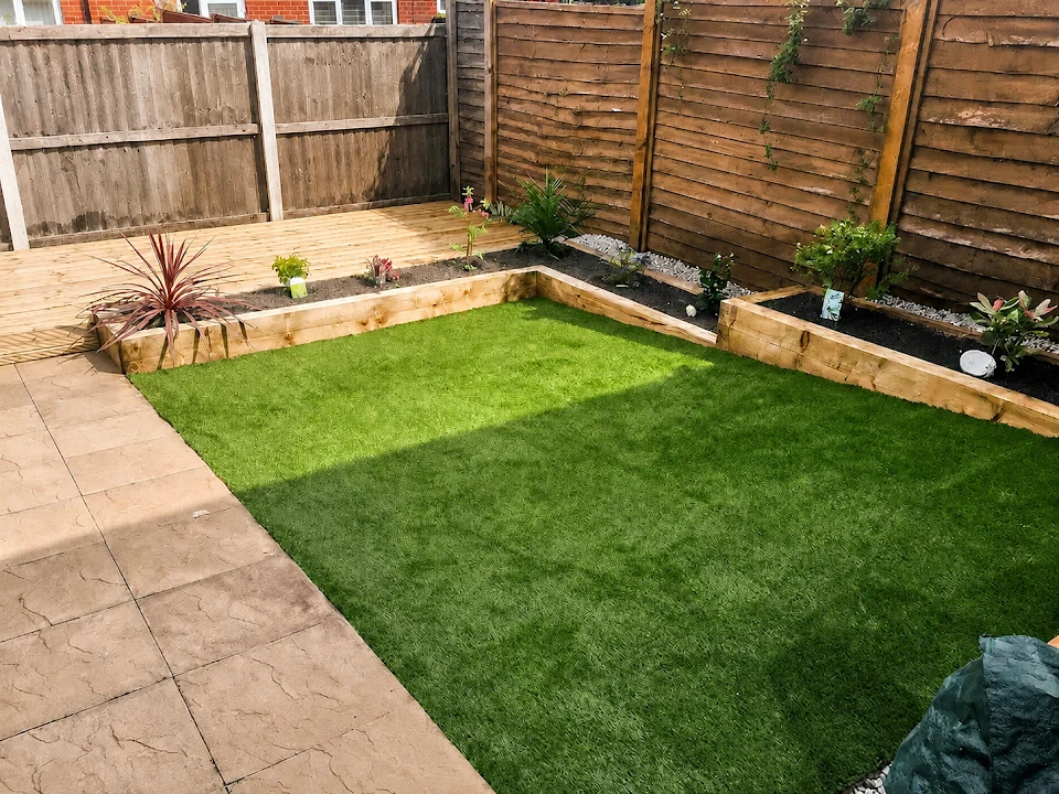 Kingsmead garden with a lawn, stone patio, timber decking and raised planting beds